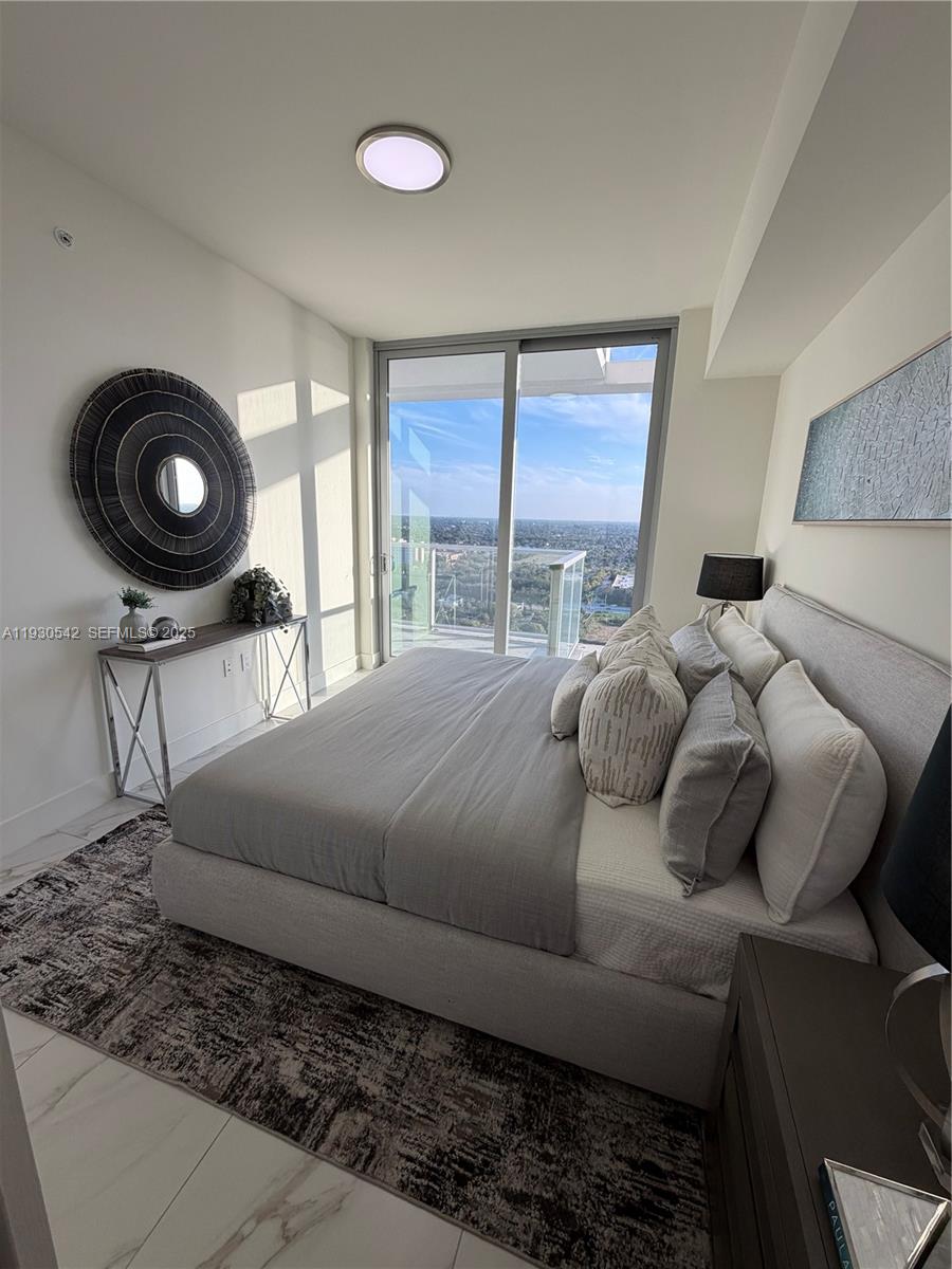 2000 Metropica Way, Unit 2108 Sunrise, FL 33323 - Photo 14 of 44 a bed sitting in a bedroom next to a window