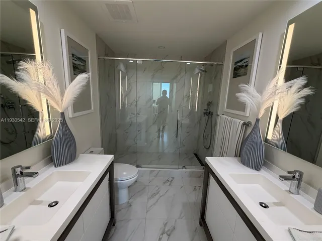 a bathroom with a sink mirror vanity and toilet