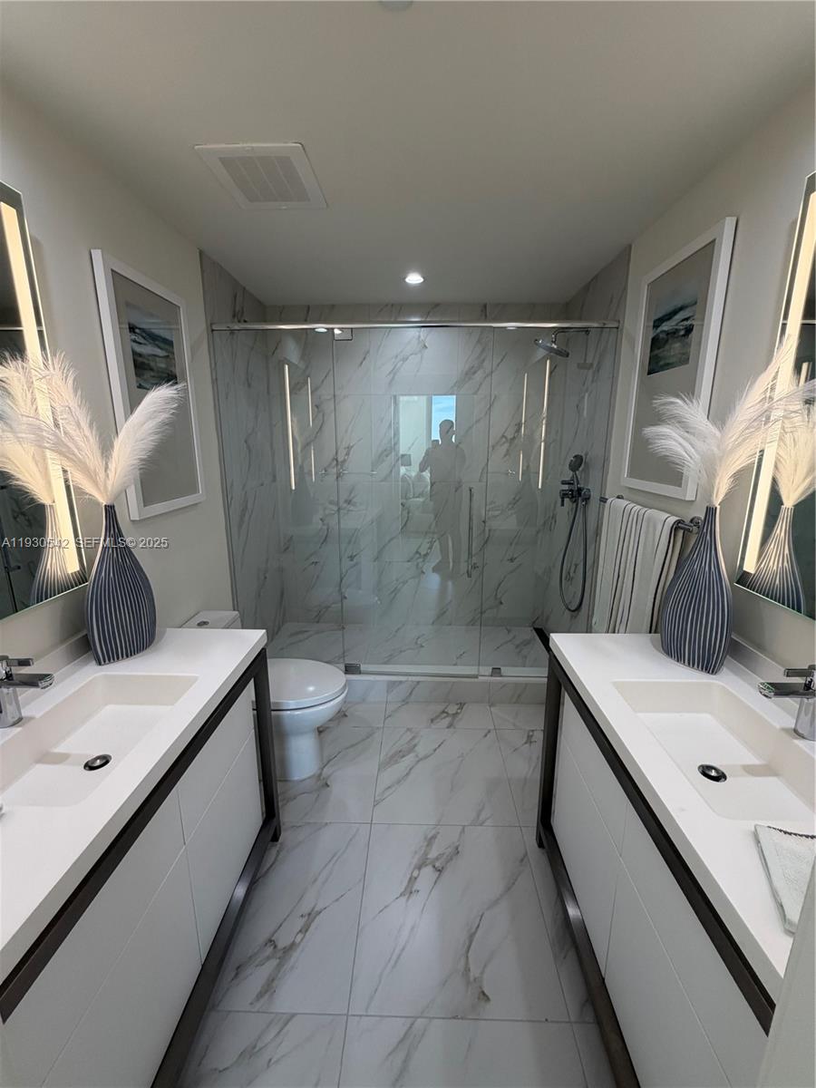 2000 Metropica Way, Unit 2108 Sunrise, FL 33323 - Photo 17 of 44 a bathroom with a sink a toilet and shower