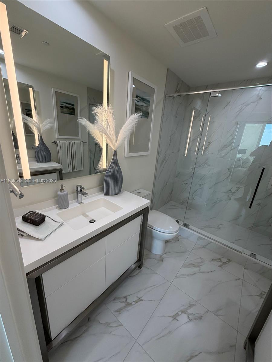 2000 Metropica Way, Unit 2108 Sunrise, FL 33323 - Photo 18 of 44 a bathroom with a sink toilet and shower