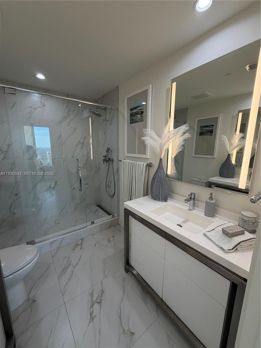 2000 Metropica Way, Unit 2108 Sunrise, FL 33323 - Photo 19 of 44 a bathroom with a granite countertop sink mirror and shower