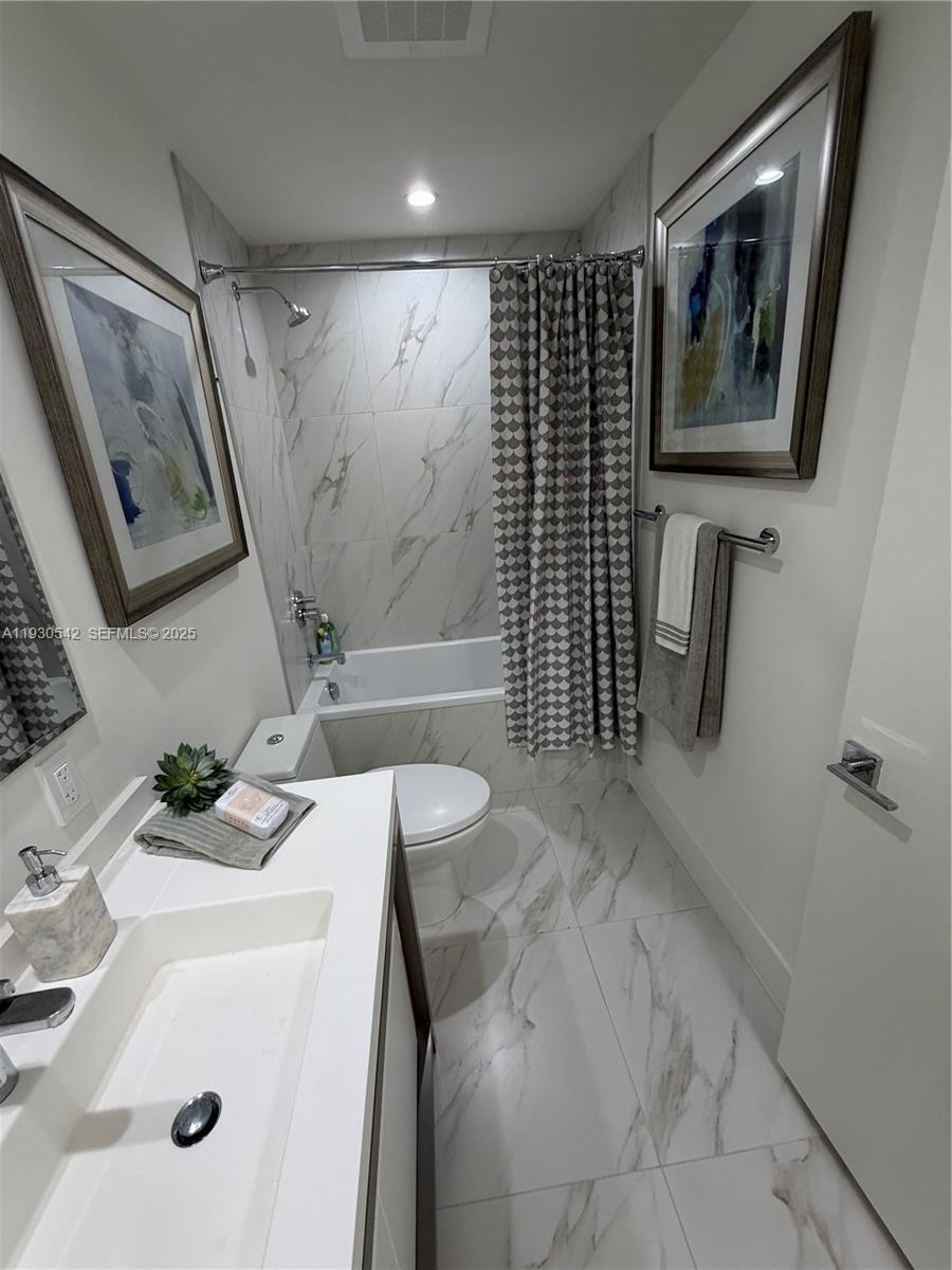 2000 Metropica Way, Unit 2108 Sunrise, FL 33323 - Photo 21 of 44 a bathroom with a sink a toilet and shower