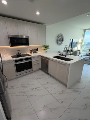 a kitchen with stainless steel appliances granite countertop a refrigerator and a stove top oven