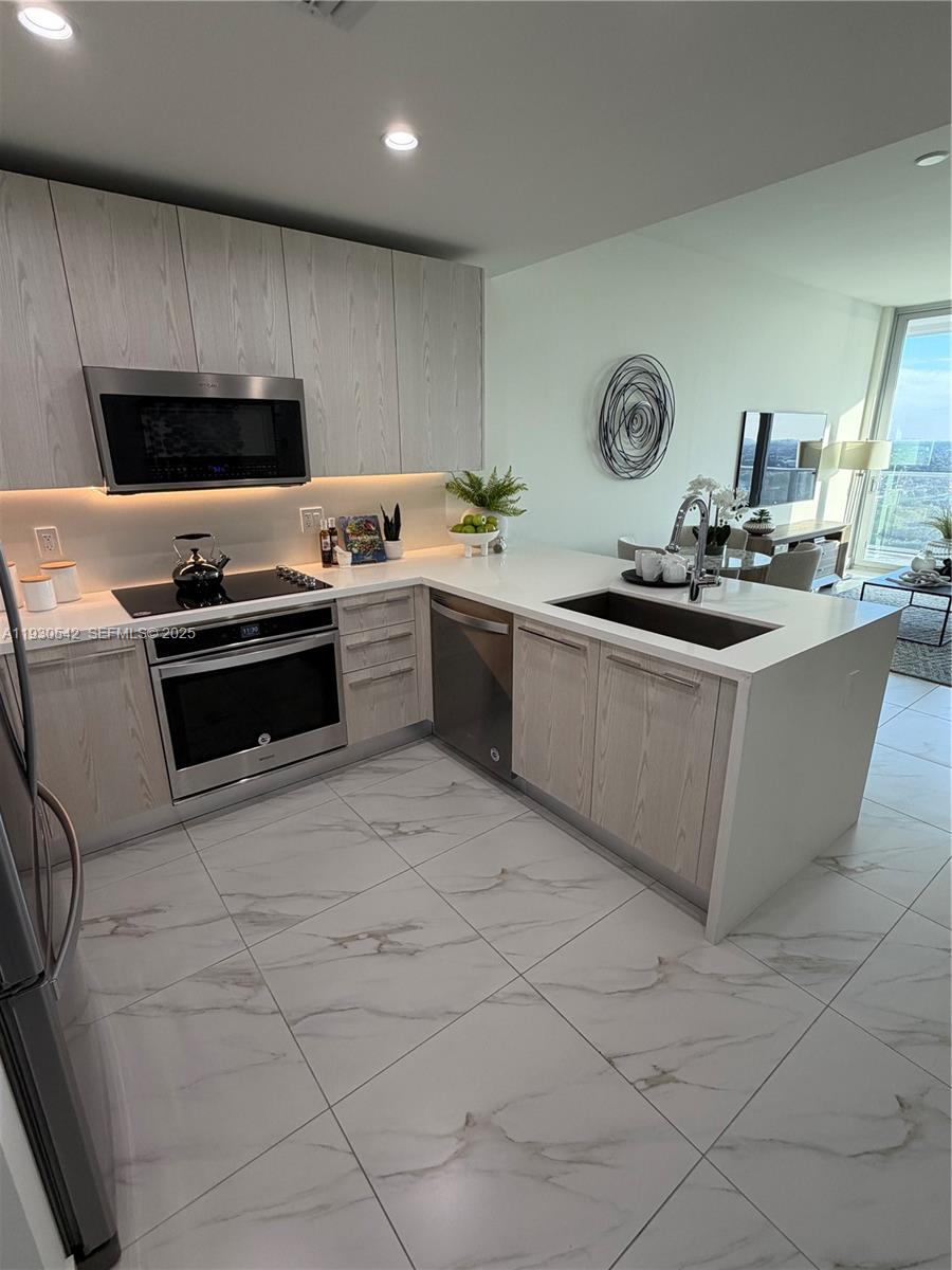 2000 Metropica Way, Unit 2108 Sunrise, FL 33323 - Photo 3 of 44 a kitchen with stainless steel appliances granite countertop a sink and a stove