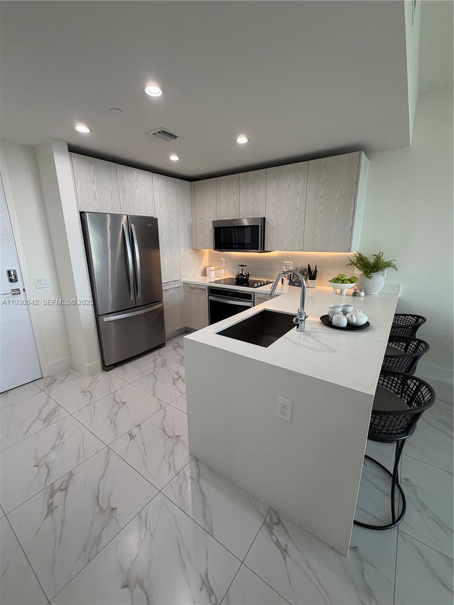 2000 Metropica Way, Unit 2108 Sunrise, FL 33323 - Photo 4 of 44 a kitchen with stainless steel appliances granite countertop a refrigerator and a stove top oven