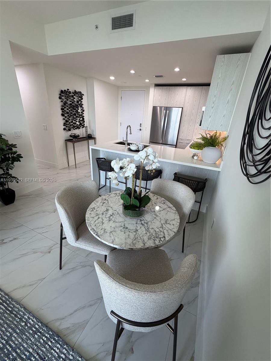 2000 Metropica Way, Unit 2108 Sunrise, FL 33323 - Photo 5 of 44 a dining room with furniture a rug and a chandelier