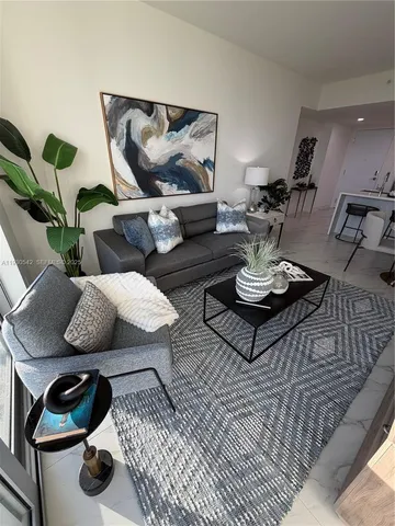 a view of a hallway and a livingroom with furniture