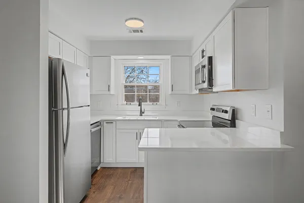 a kitchen with stainless steel appliances granite countertop a refrigerator and a sink