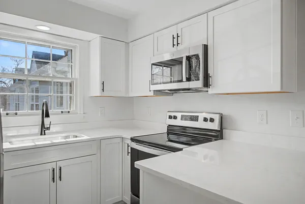 a kitchen with stainless steel appliances a sink a stove and cabinets