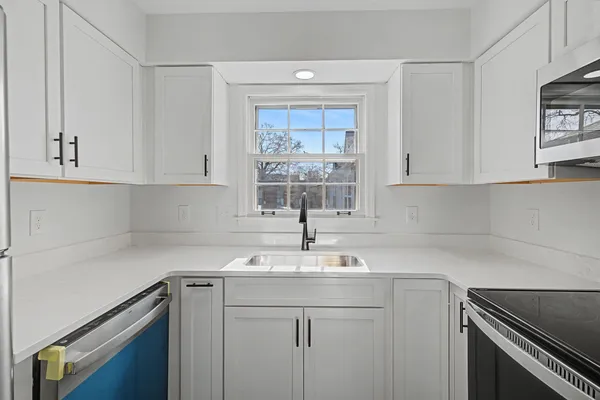 a kitchen with a sink cabinets and window