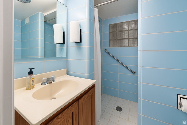 16535 South Redwood Road Riverton, UT 84065 - Photo 34 of 59 Bathroom featuring blue wall tiling, a vanity with an integrated sink, a mirrored medicine cabinet, and a shower with a glass block window