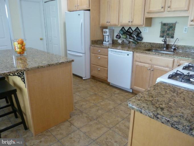 12908 Bluhill Road Silver Spring, MD 20906 - Photo 4 of 26 a kitchen with stainless steel appliances granite countertop a sink stove and refrigerator