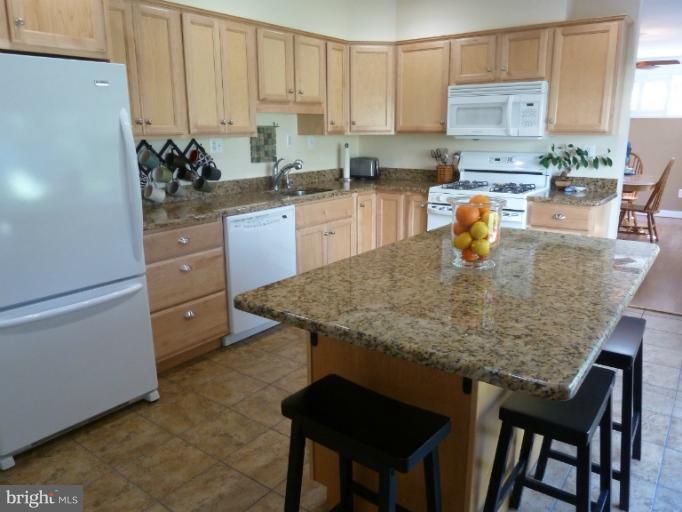 12908 Bluhill Road Silver Spring, MD 20906 - Photo 8 of 26 a kitchen with a table chairs and cabinets