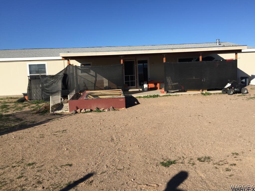 3995 Eloy Road, Unit 66 Golden Valley, AZ 86413 - Photo 26 of 27 a backyard of a house with table and chairs