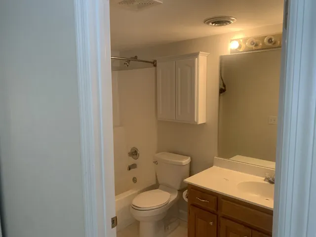 a bathroom with a granite countertop toilet and a sink