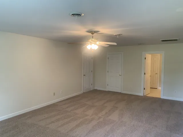 a view of an empty room and a ceiling fan