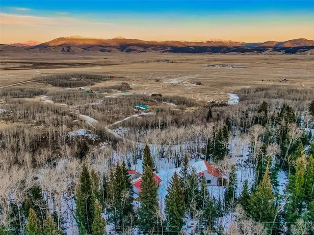 a view of a house with a mountain and a forest