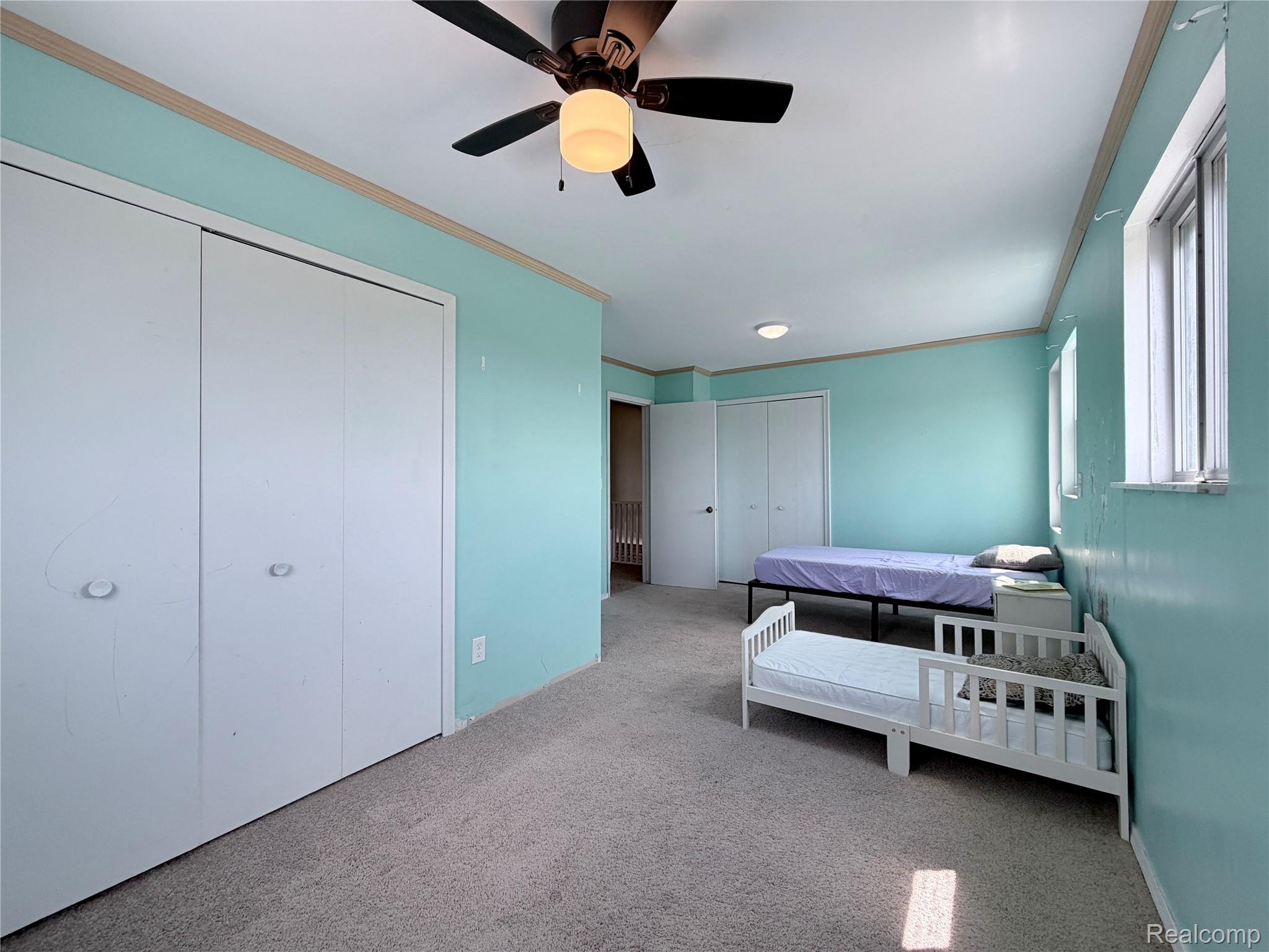 10865 Norman Road Yale, MI 48097 - Photo 16 of 23 Carpeted room featuring multiple windows, a ceiling fan, and built-in closet storage with bi-fold doors