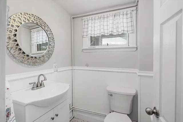 a bathroom with a toilet a sink and mirror