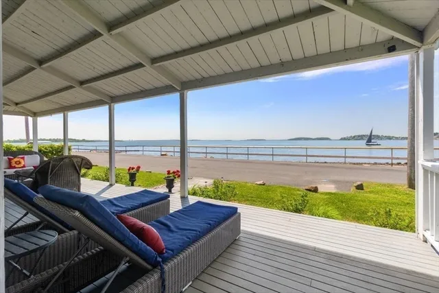 a view of a balcony with couple of chairs and couches with wooden floor