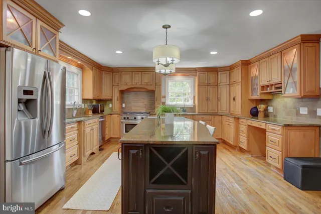a kitchen with stainless steel appliances granite countertop a stove a sink and a refrigerator