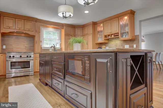 a kitchen with stainless steel appliances granite countertop a sink a stove and cabinets