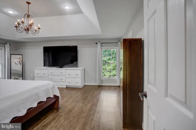 a spacious bedroom with a bed and a flat screen tv