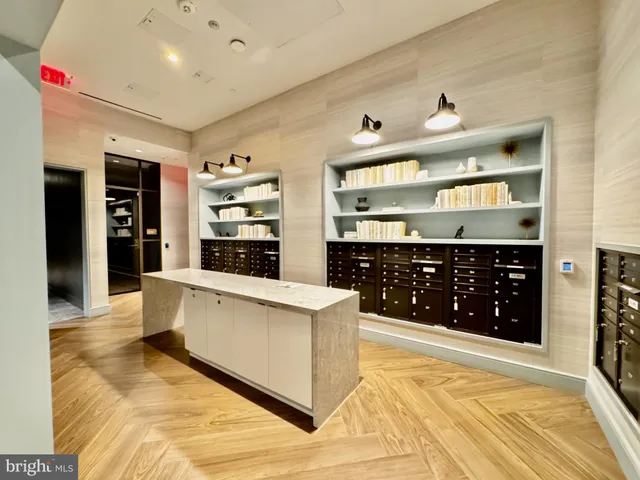 a large white kitchen with stainless steel appliances a large counter top a stove and a refrigerator