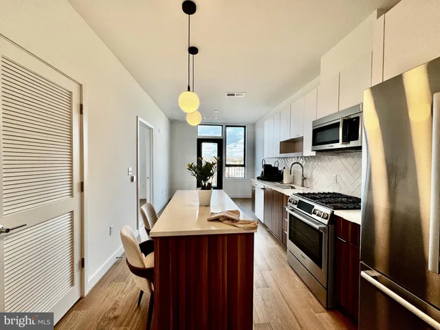 a kitchen with stainless steel appliances a stove refrigerator sink and microwave