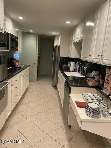 a kitchen with stainless steel appliances kitchen island granite countertop a sink and cabinets