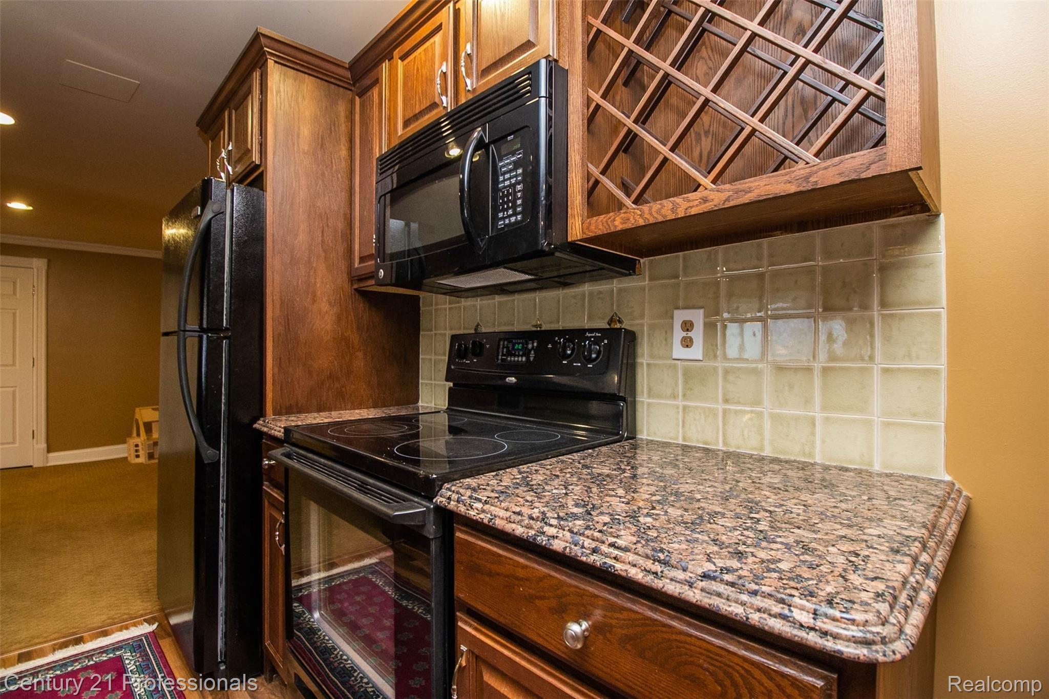 69401 Eldred Road Romeo, MI 48065 - Photo 48 of 65 Wine Rack, Microwave and Elec Stove w/ frig on back wall in Basement Kitchen