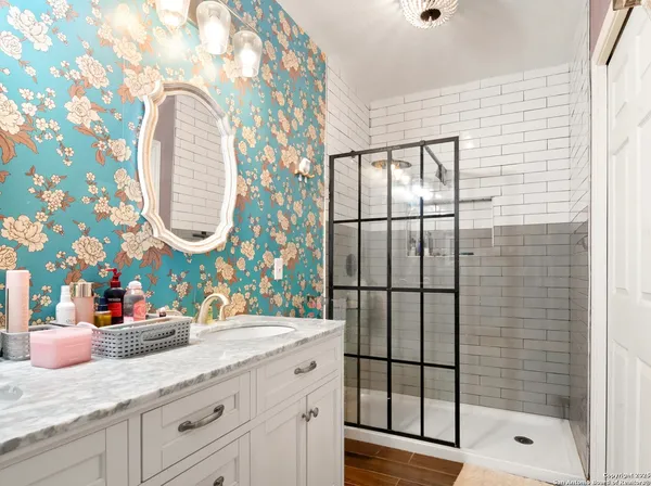 a bathroom with a granite countertop sink mirror and vanity