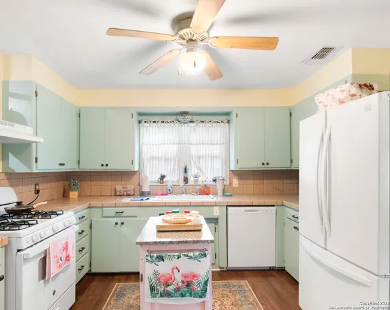 a kitchen with a sink a stove a refrigerator and a window