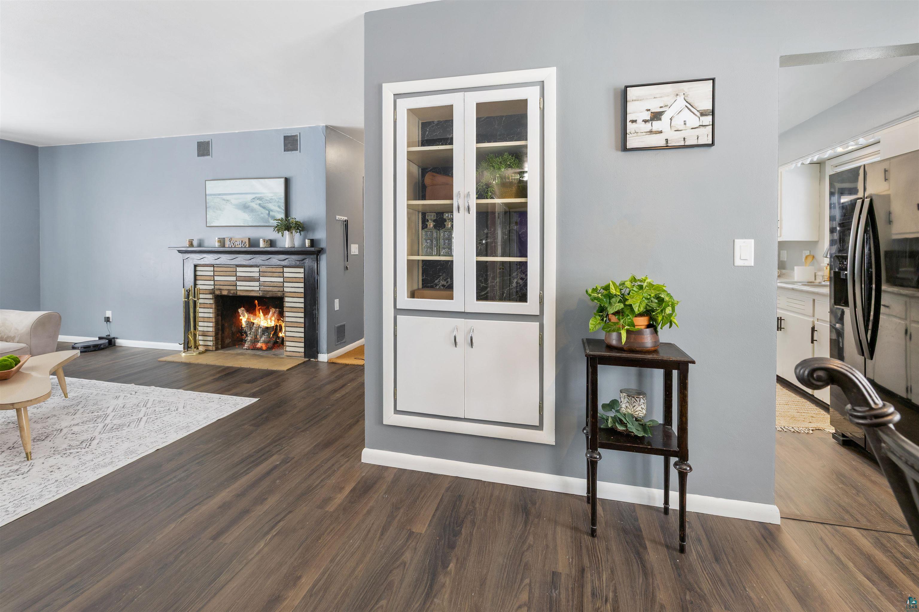 1101 13th Street South Virginia, MN 55792 - Photo 12 of 43 Living area with a wood burning fireplace with flush hearth and dark laminate flooring