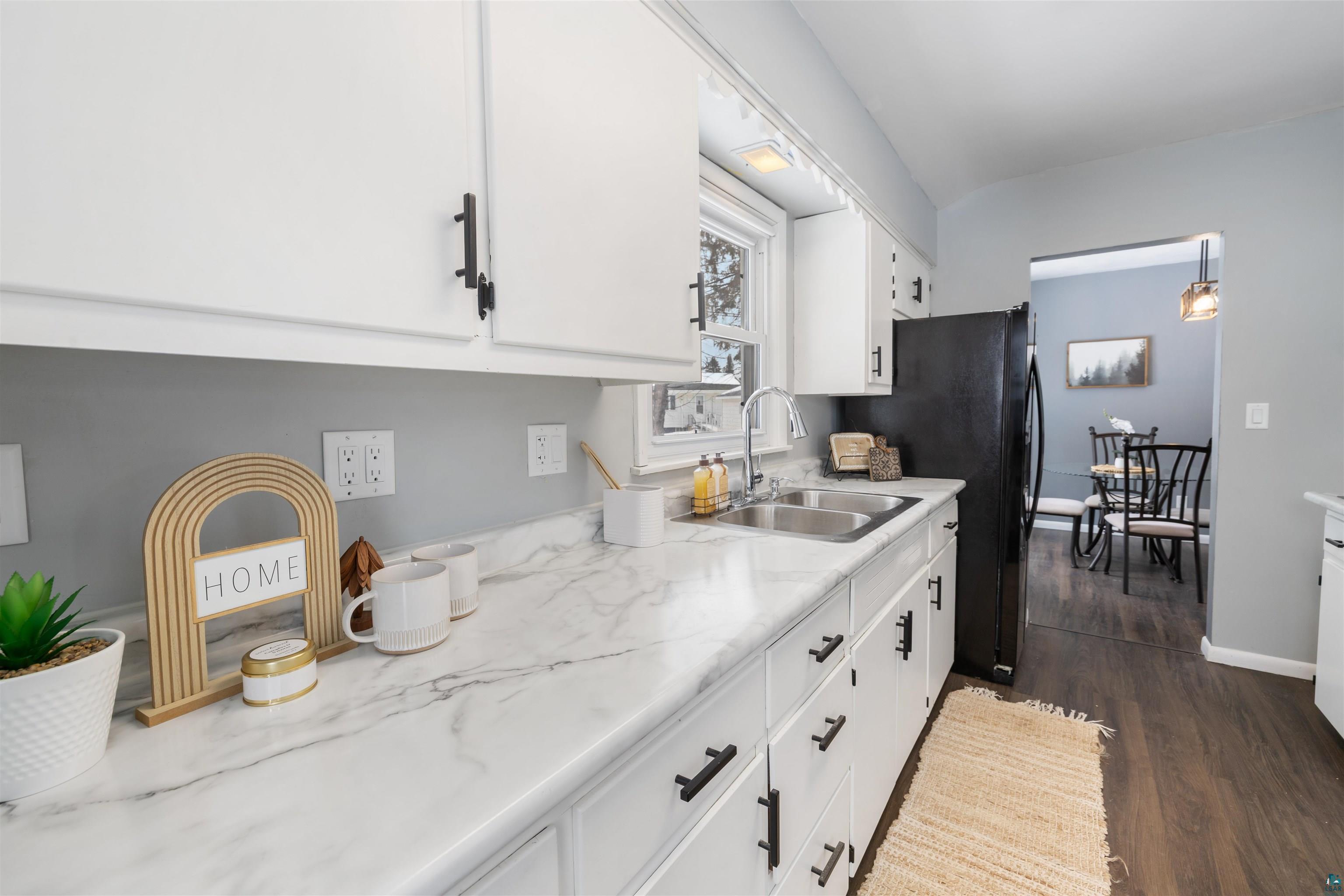 1101 13th Street South Virginia, MN 55792 - Photo 2 of 43 Kitchen with light laminate countertops, white cabinets, dark laminate flooring, and freestanding refrigerator