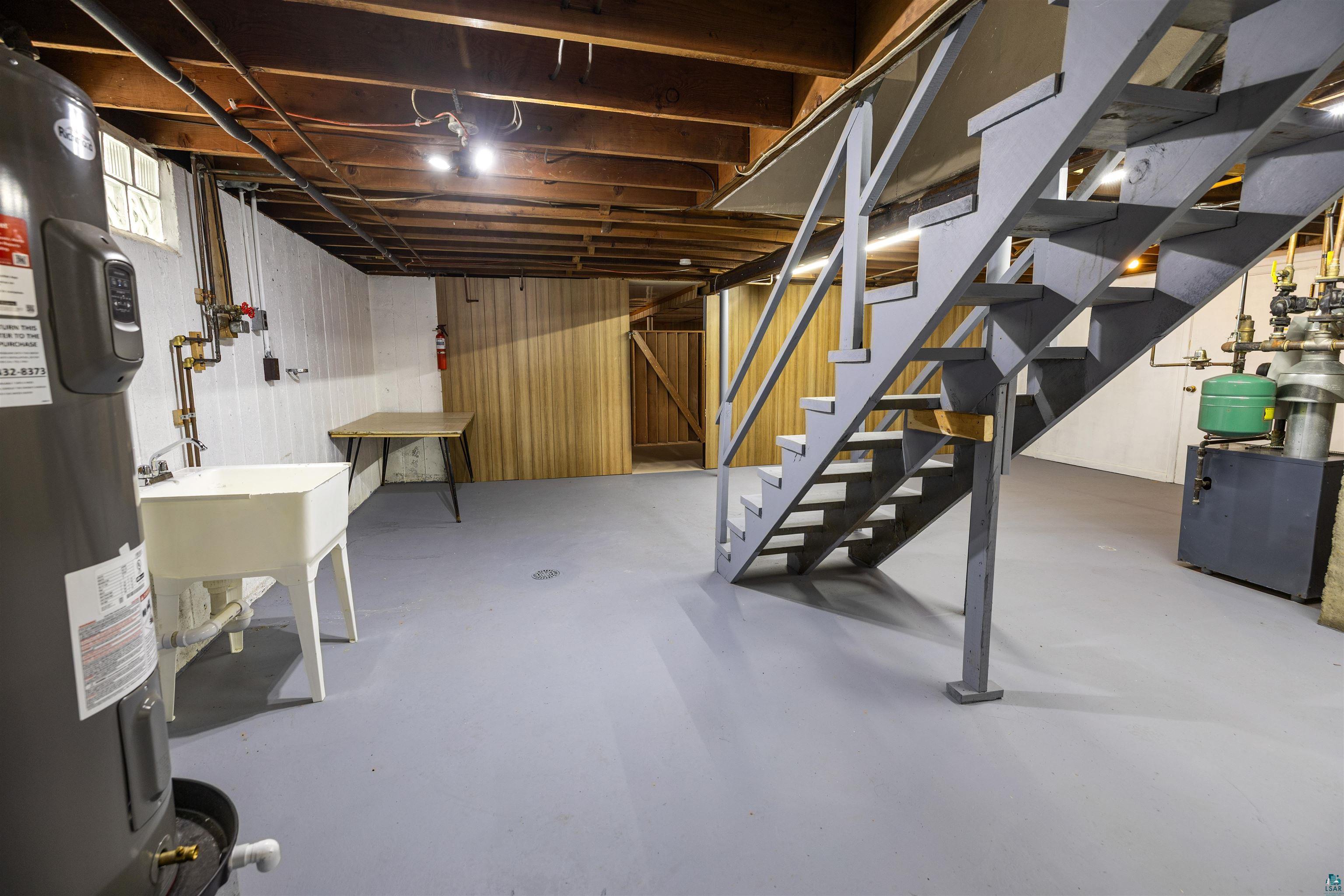 1101 13th Street South Virginia, MN 55792 - Photo 32 of 43 Basement with water heater, paneled walls, and a heating unit