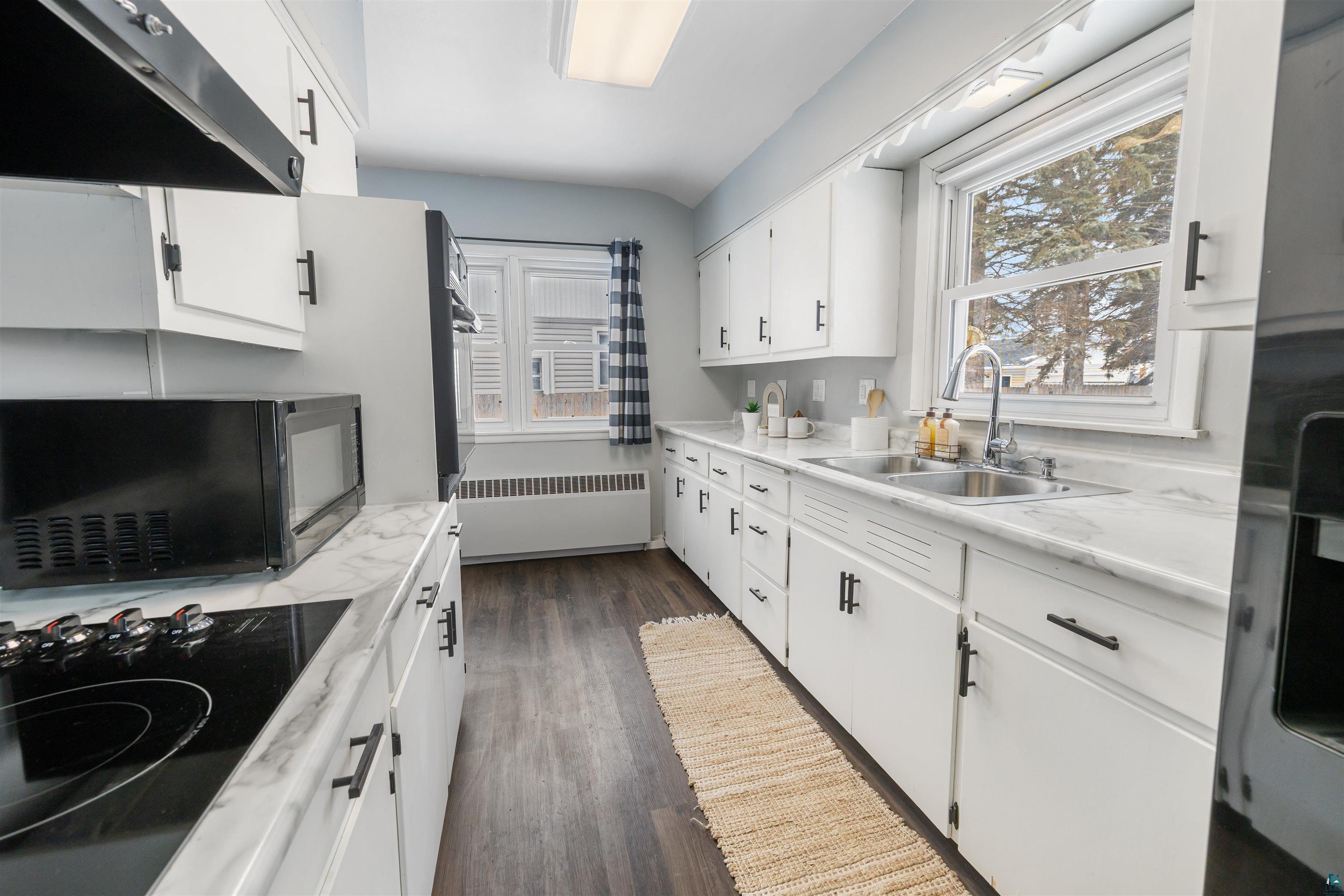 1101 13th Street South Virginia, MN 55792 - Photo 4 of 43 Kitchen featuring white cabinetry, black appliances, light laminate countertops, and dark laminate flooring