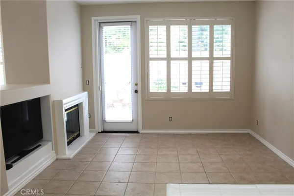 a view of an empty room with a fireplace and a window
