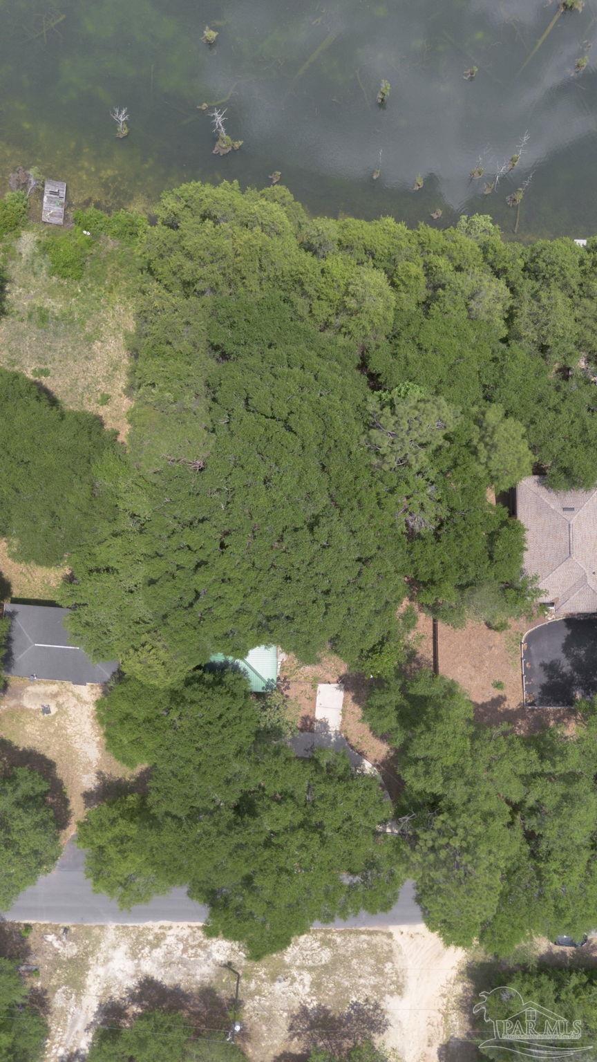 10290 West Lake Road Milton, FL 32583 - Photo 45 of 53 a backyard of a building with trees in the background