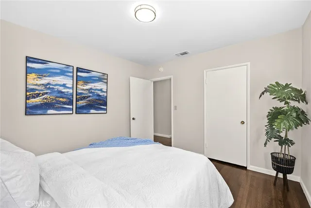 a bedroom with a bed and a potted plant next to a window