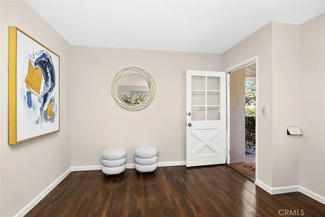 a view of bathroom with toilet and a painting on the wall