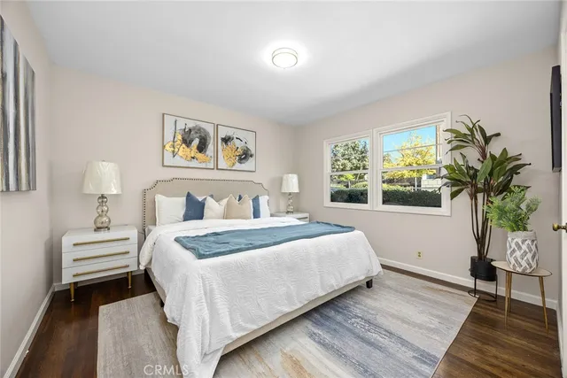 a bedroom with a large bed and a potted plant