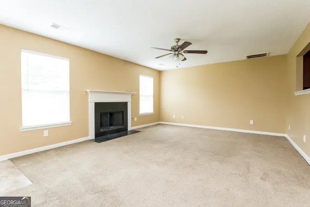a view of an empty room with a fireplace and a window