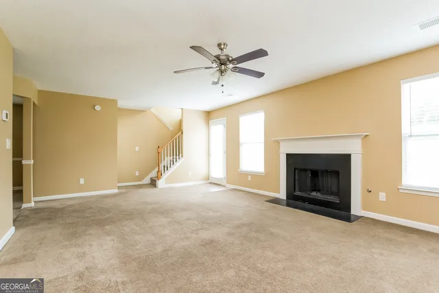 a view of an empty room with a fireplace and a window