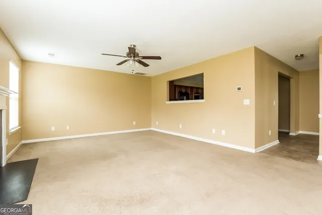 a view of an empty room with a ceiling fan