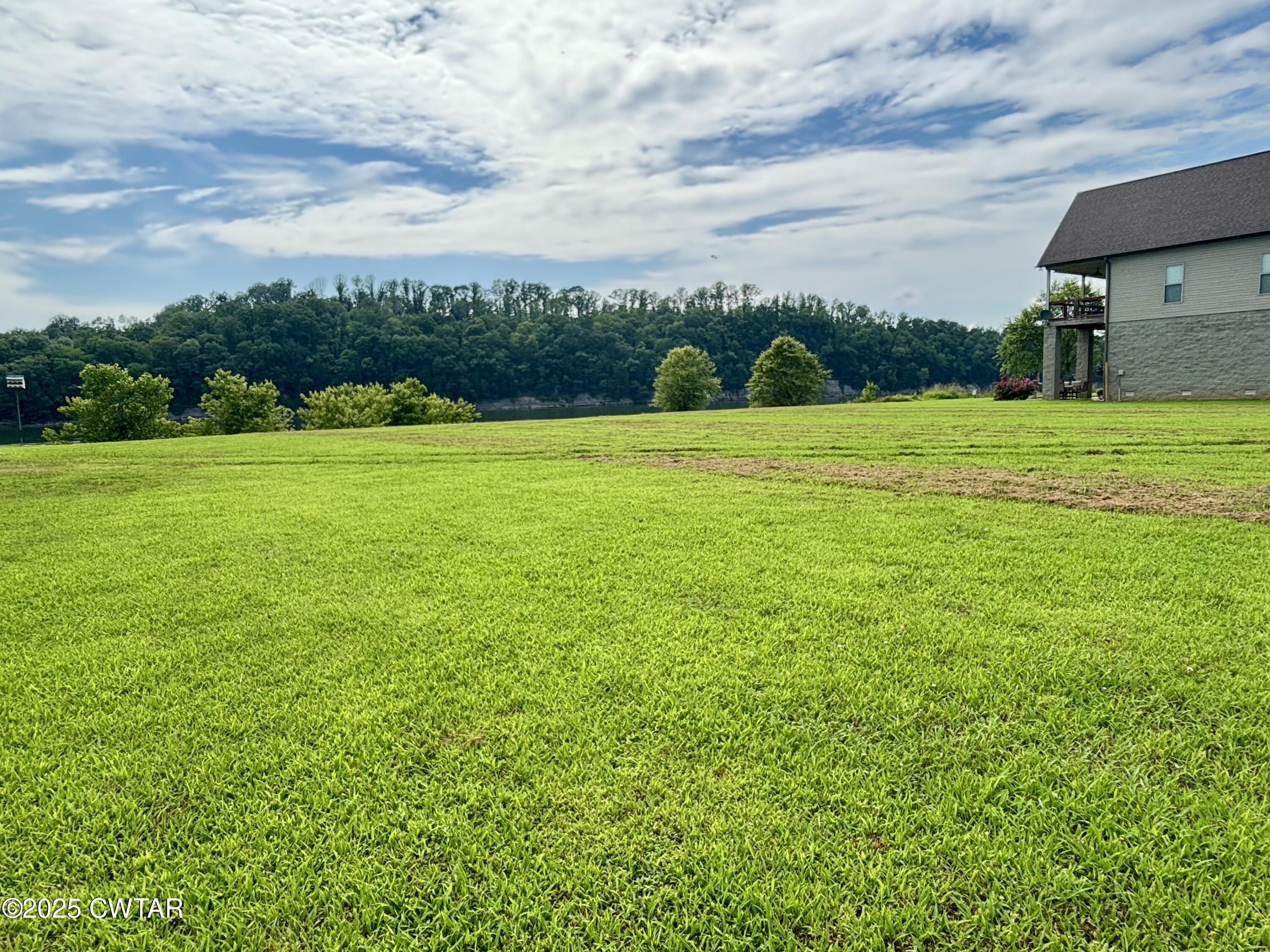 995 Hardin Bottom River Road Clifton, TN 38425 - Photo 5 of 8 a view of a field of grass and a building