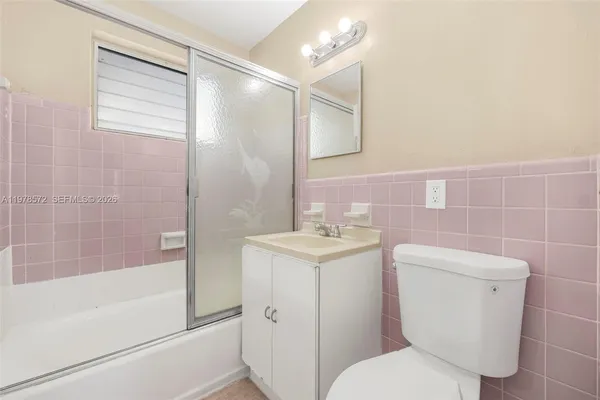 a white toilet sitting next to a bath tub