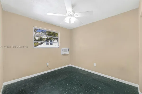 an empty room with a window and a ceiling fan
