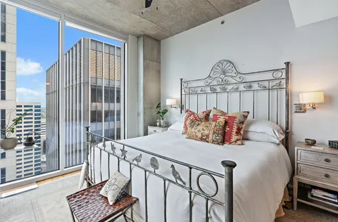 a bedroom with a large window and a bed