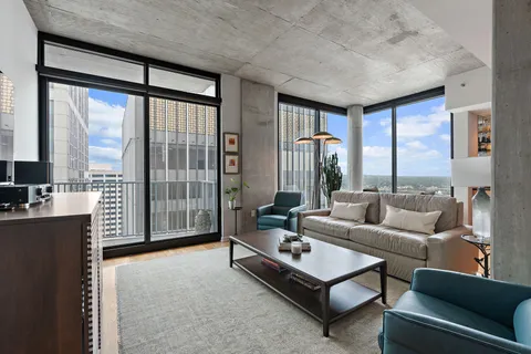 a living room with furniture windows and a flat screen tv